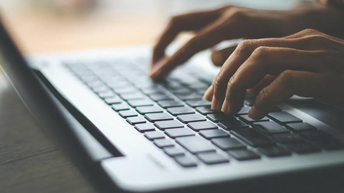 Hands on a laptop keyboard