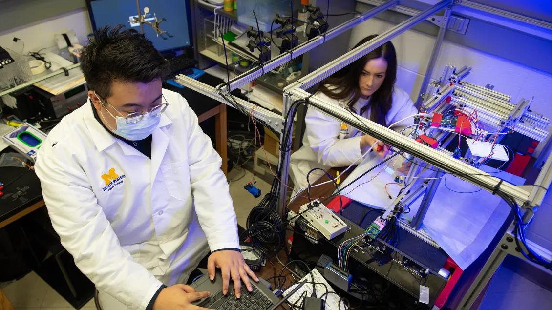 view from above of two researchers working on medical machinery 