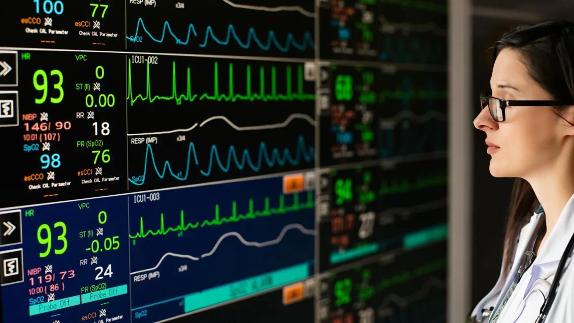 A female physician examines a critical care dashboard