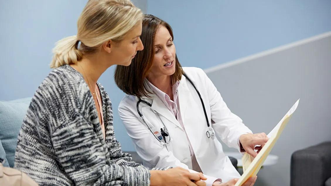 CanSORT - Female physician pointing out results on paper