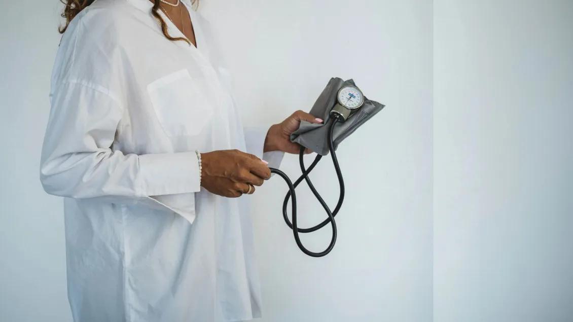 Brainhealth - Woman holds a blood pressure monitor