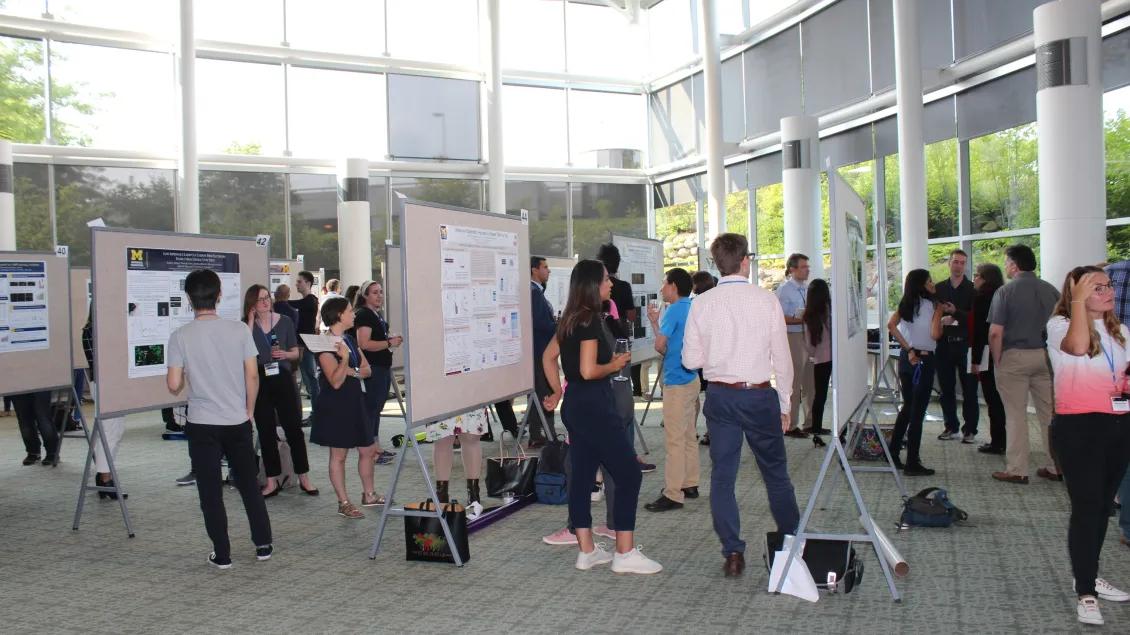 groups of people viewing academic posters at an event