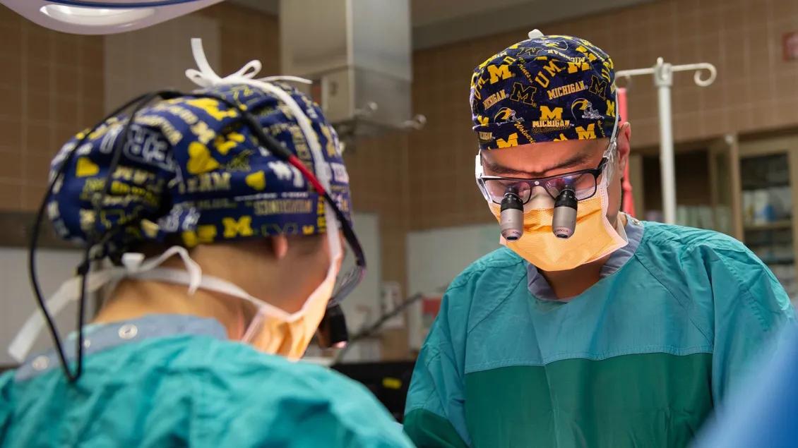 Two surgeons focused on a procedure in an operating room