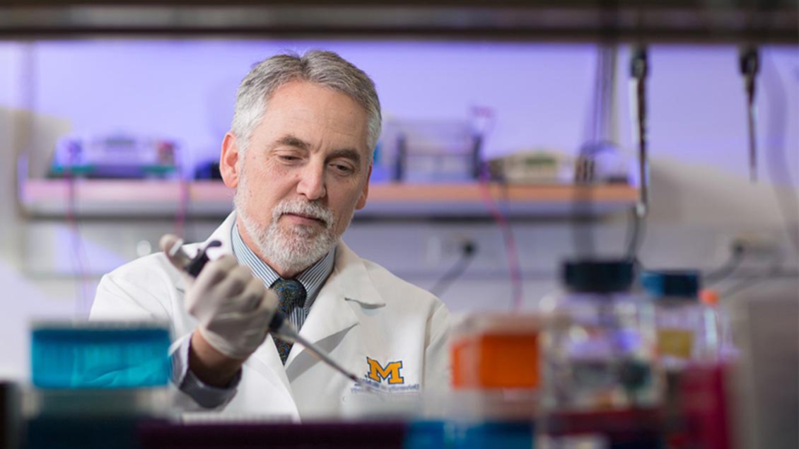 Henry Paulson, M.D., Ph.D., working in a laboratory.
