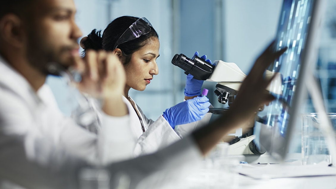 Two researchers in white coats working in a laboratory.