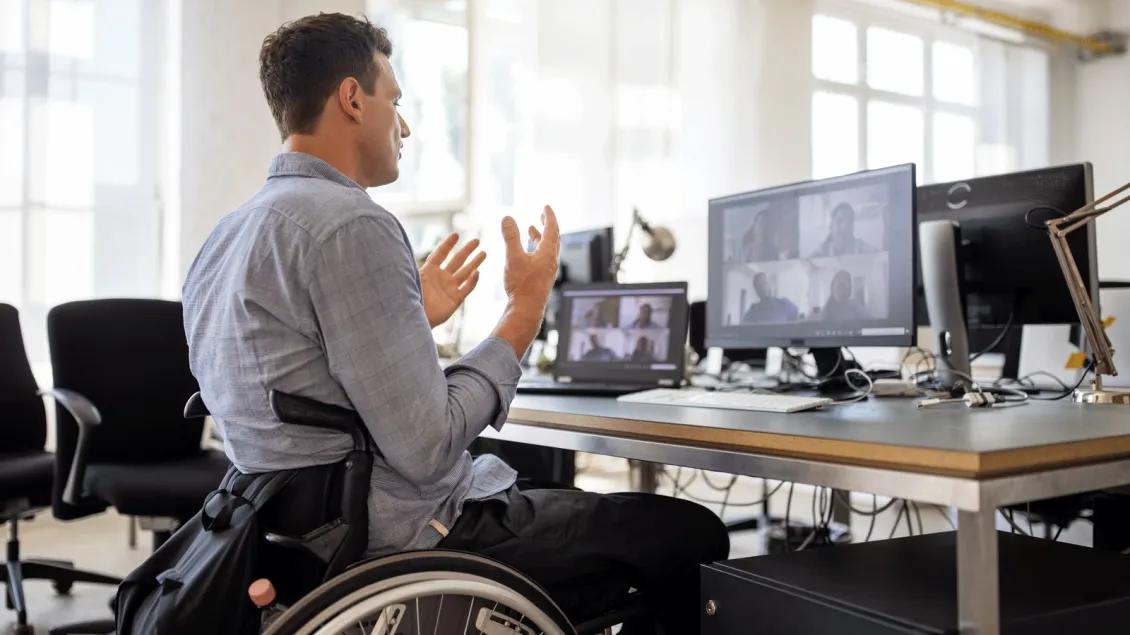 Young man in a wheelchair uses his hands expressively on a video call