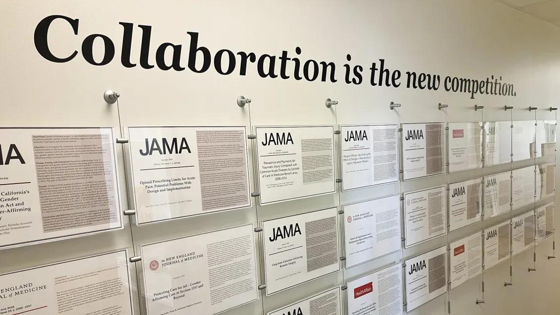 Wall at the CHOP offices displaying abstracts that says "Collaboration is the new competition"