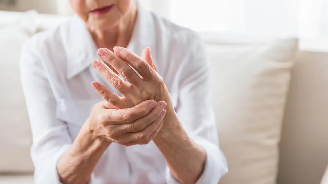 an older women holding her hand that is in pain