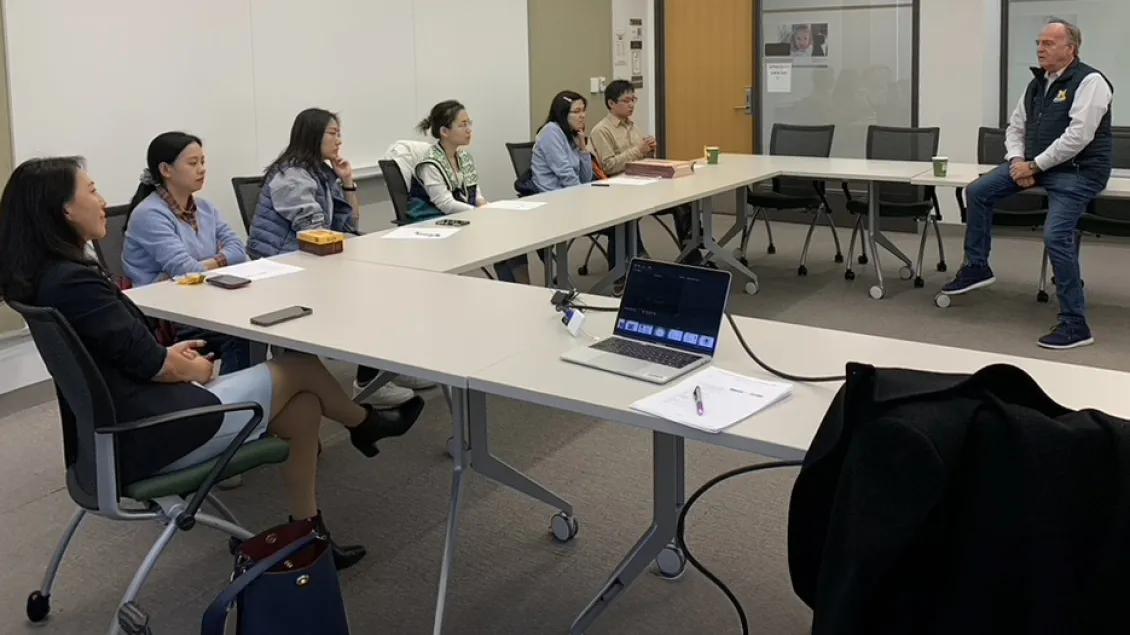 people gathered around a conference table during a Scholars Meeting