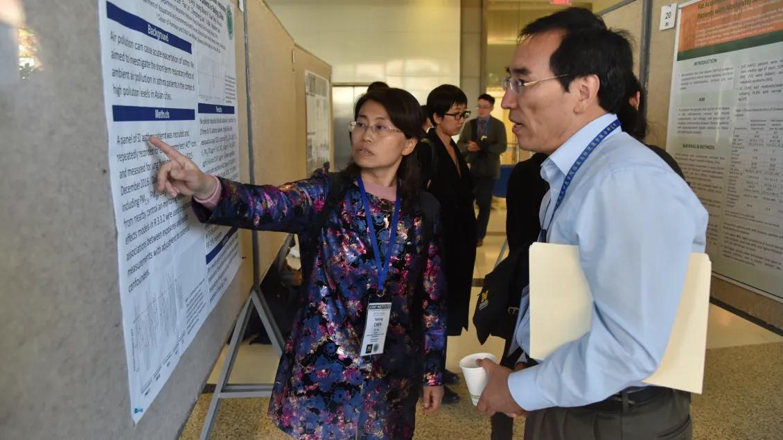 people gathering to look at poster presentations