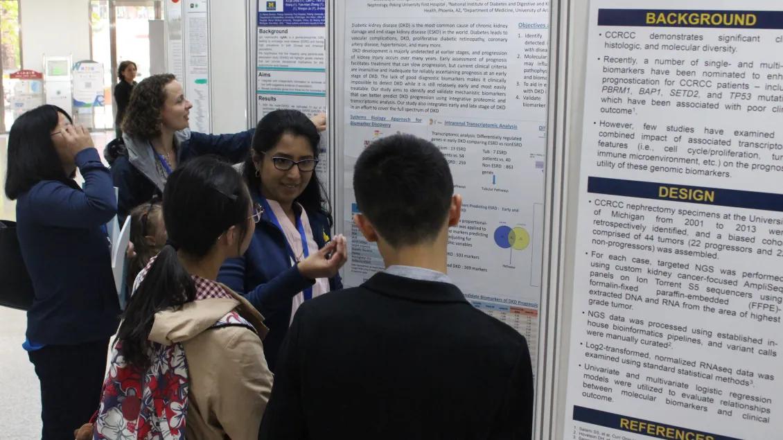 people gathering to look at poster presentations