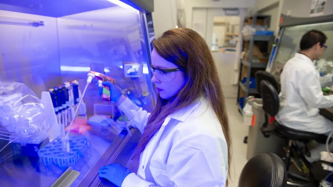 Lab personnel working in the lab with equipment