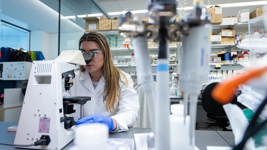 Scientist at microscope in food allergy lab