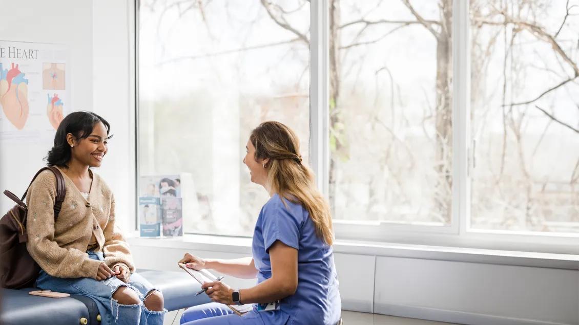 nurse and woman speaking in patient room