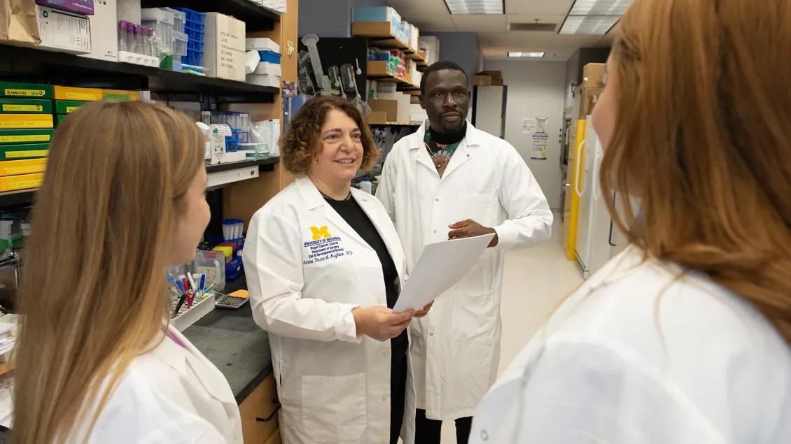 Dr. Pasca di Magliano and lab members talking in the lab