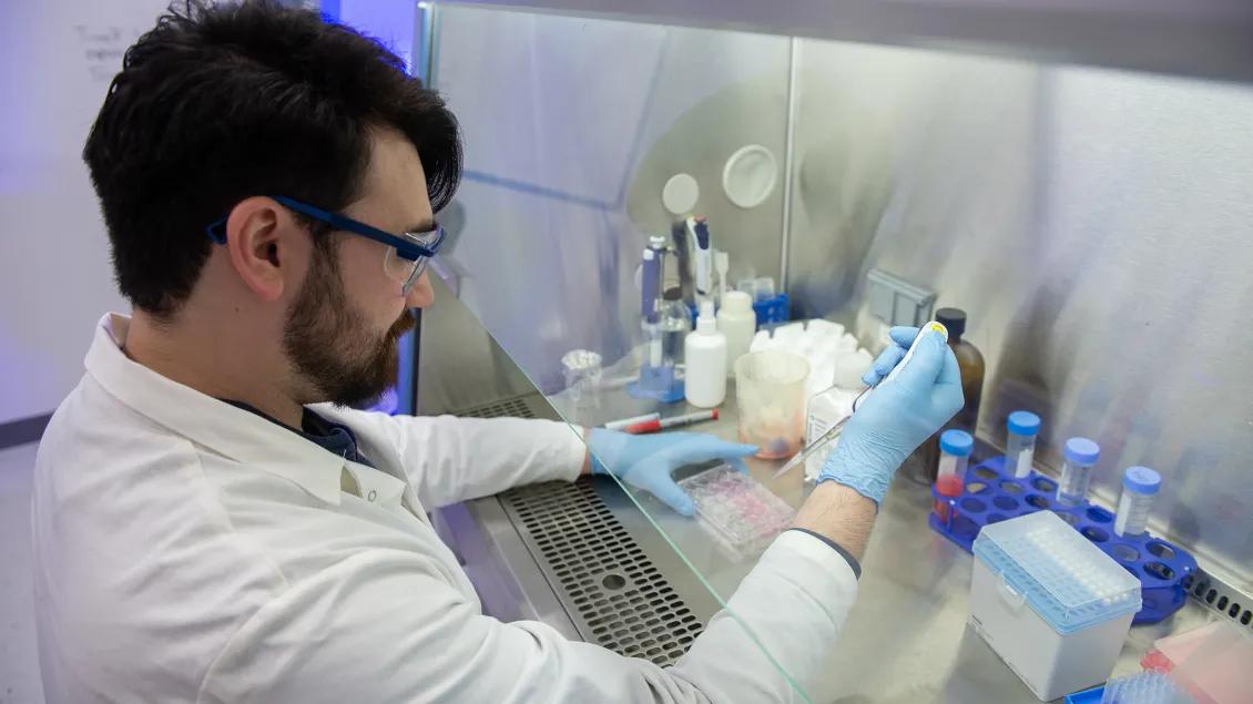 Lab personnel working in the lab with equipment