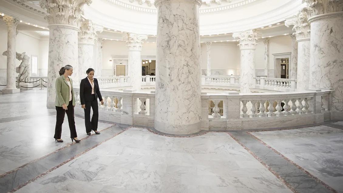 two women walking in large marble building