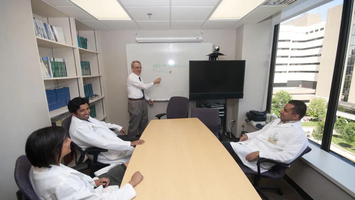 four researchers in a conference room meeting