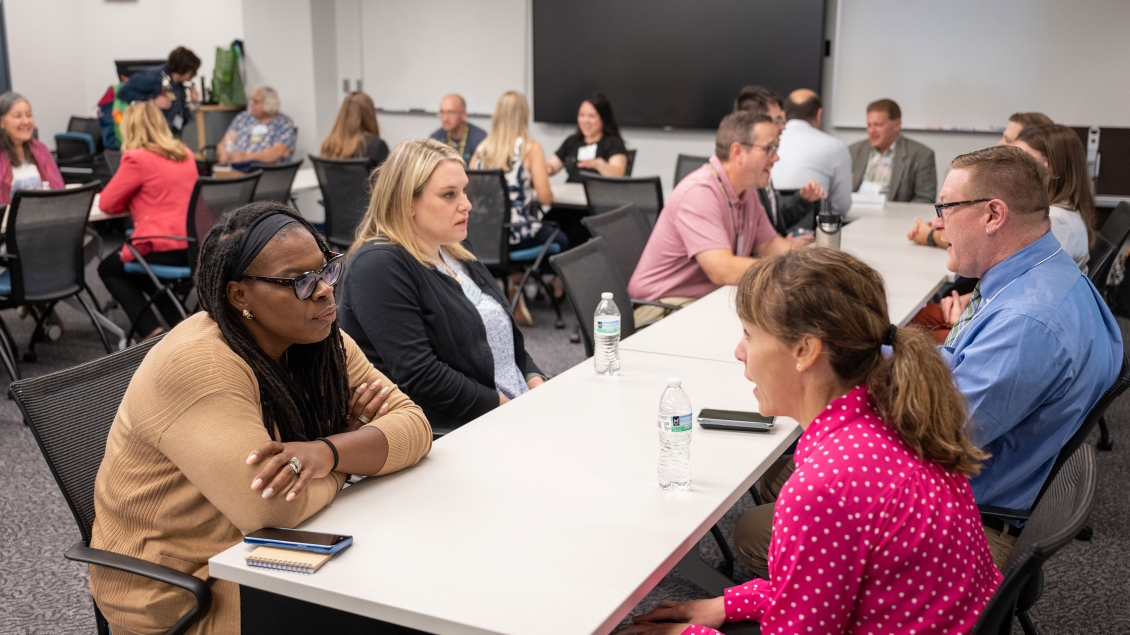 People sitting at tables and talking in a classroom