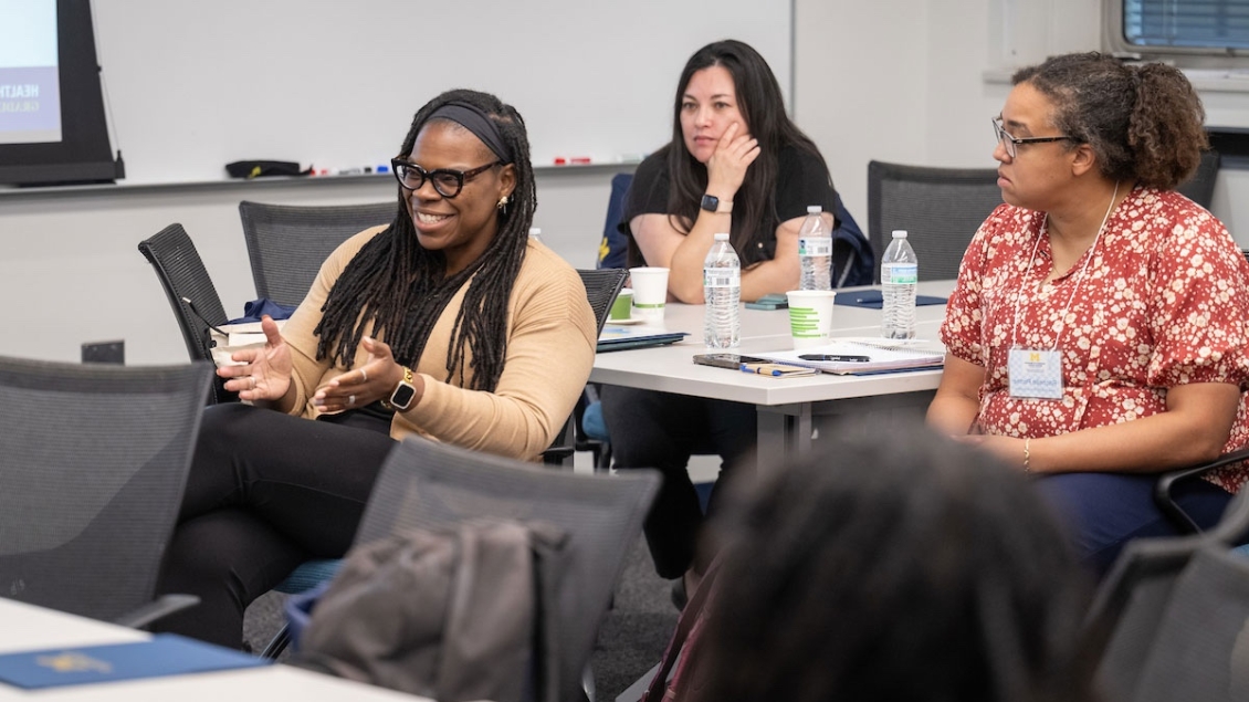 People sitting at tables and talking in a classroom