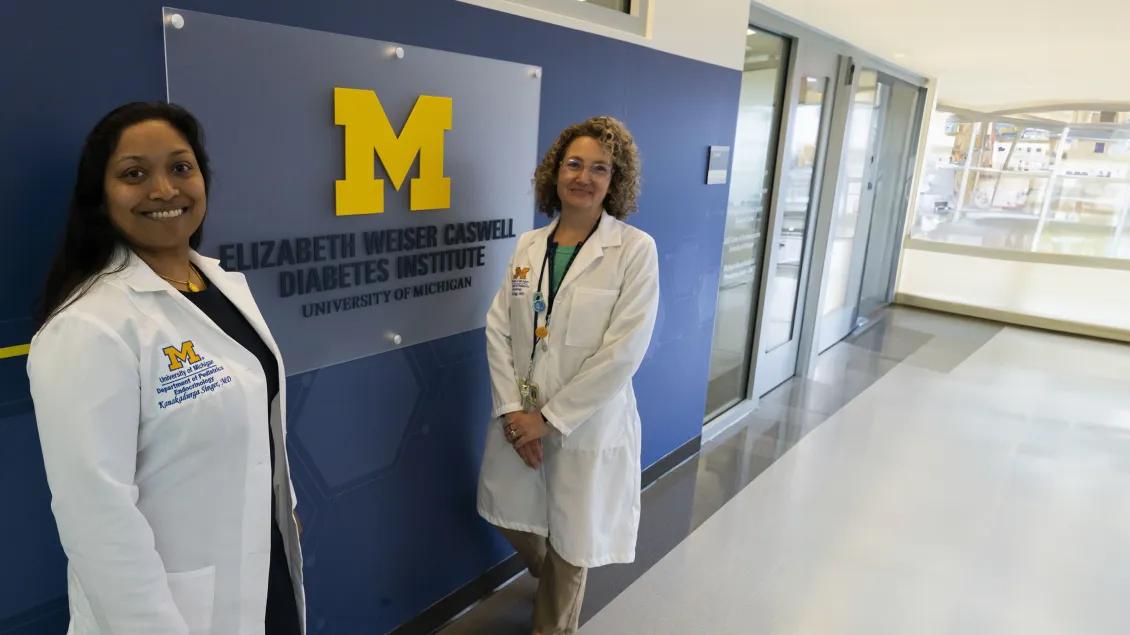 two doctors posing next to the Caswell sign