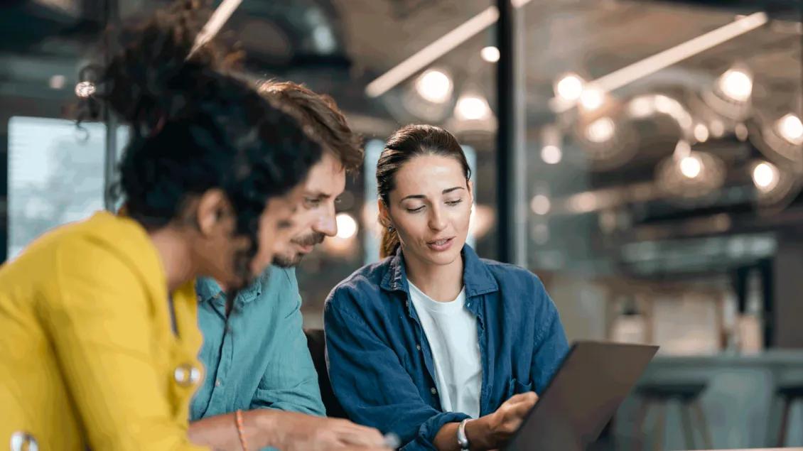 Woman explaining information on computer screen to two students