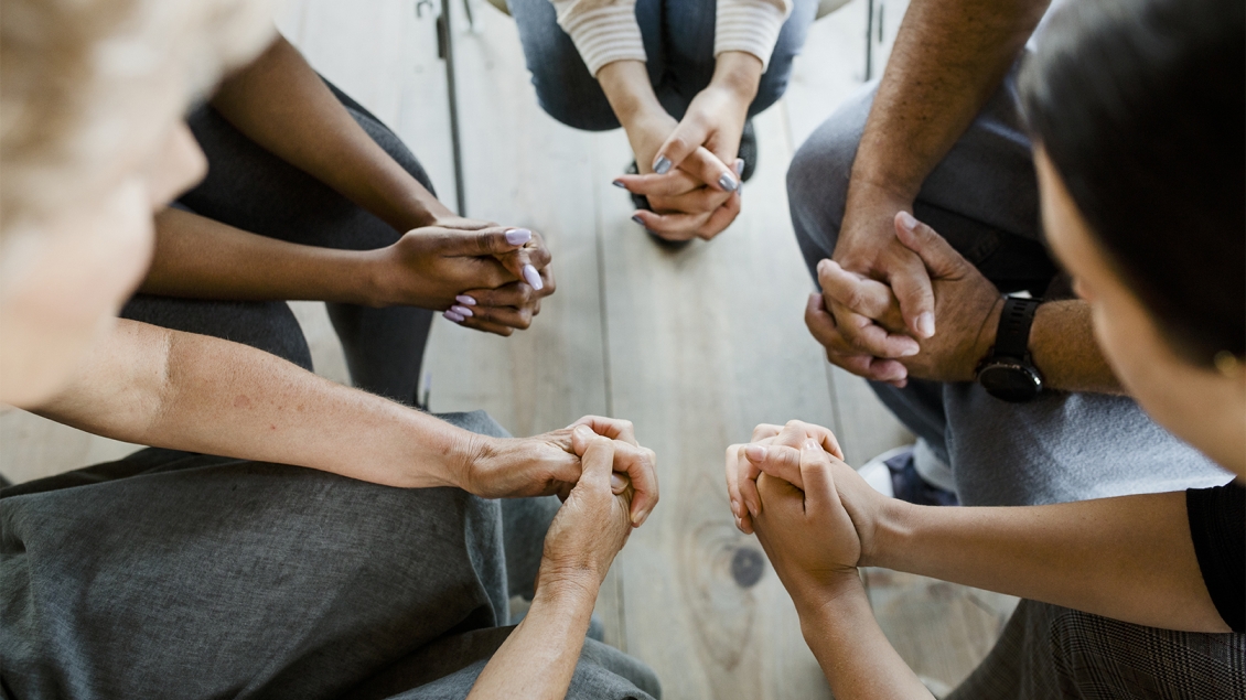 close-up of hands folded in a group