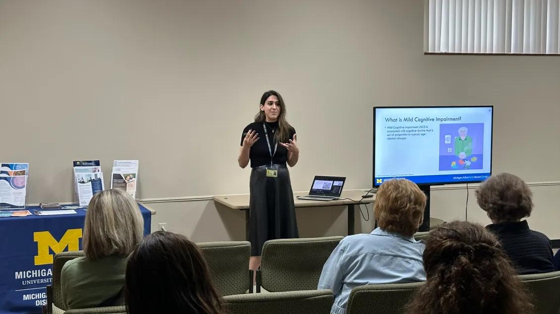 a woman presenting in front of a crowd