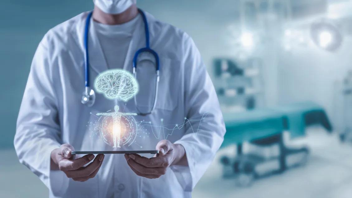 Physician holding tablet with projection of brain & anatomy visually appearing above