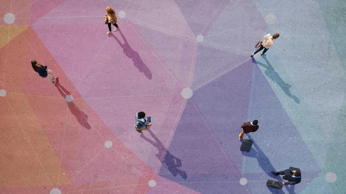 Overhead view of people walking across a multi-colored paved surface