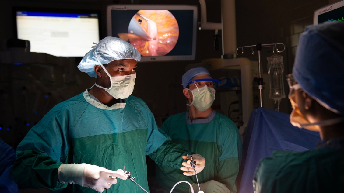 Three thoracic surgeons perform a procedure in an operating room.