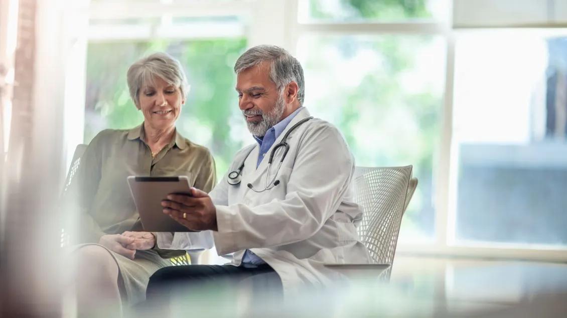 Physician showing woman information on a tablet