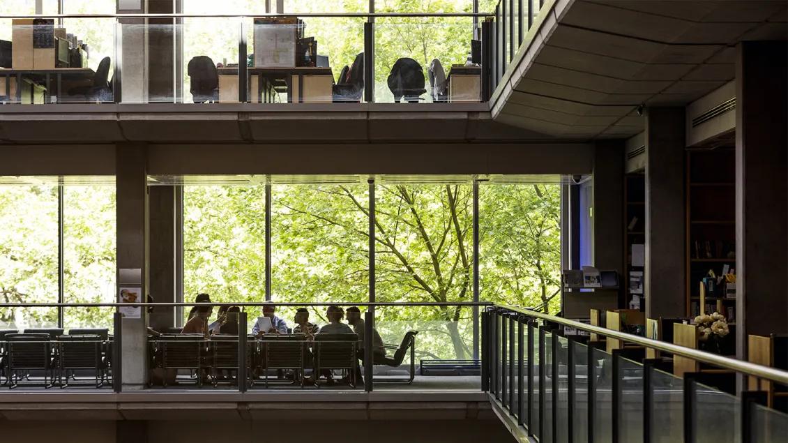 groups of people working in a large office building, at a distance