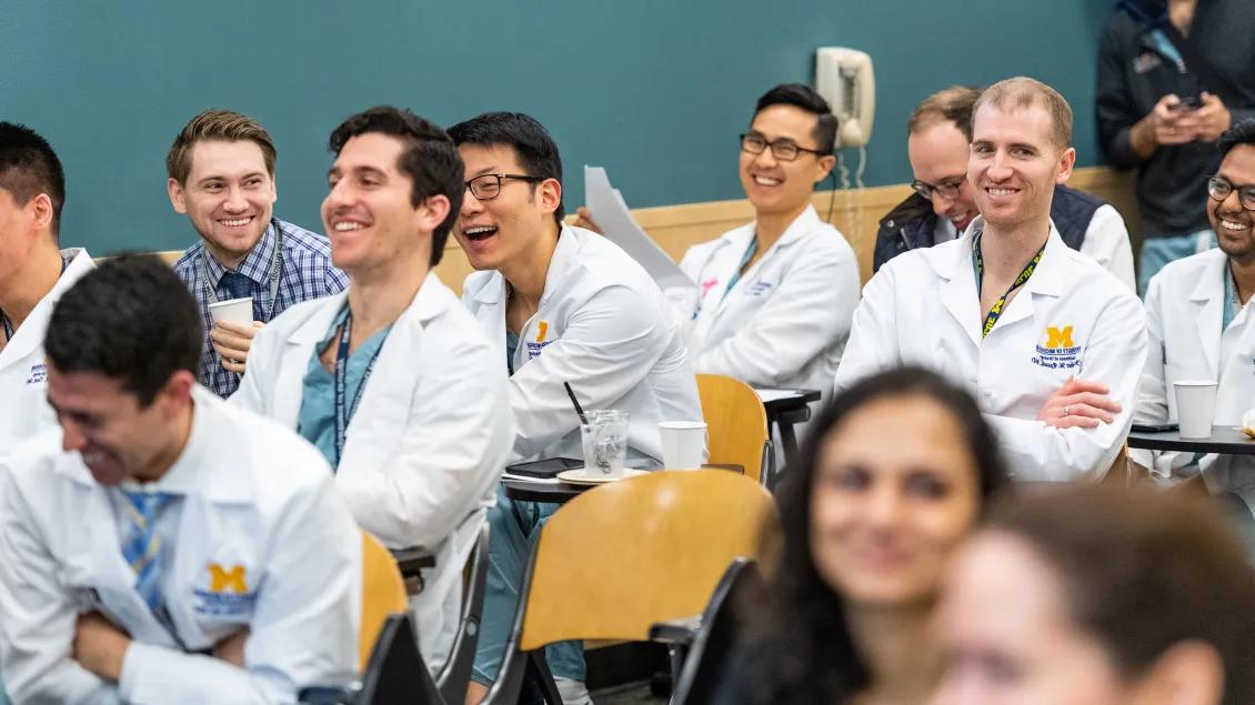Urology residents laughing in an auditorium 
