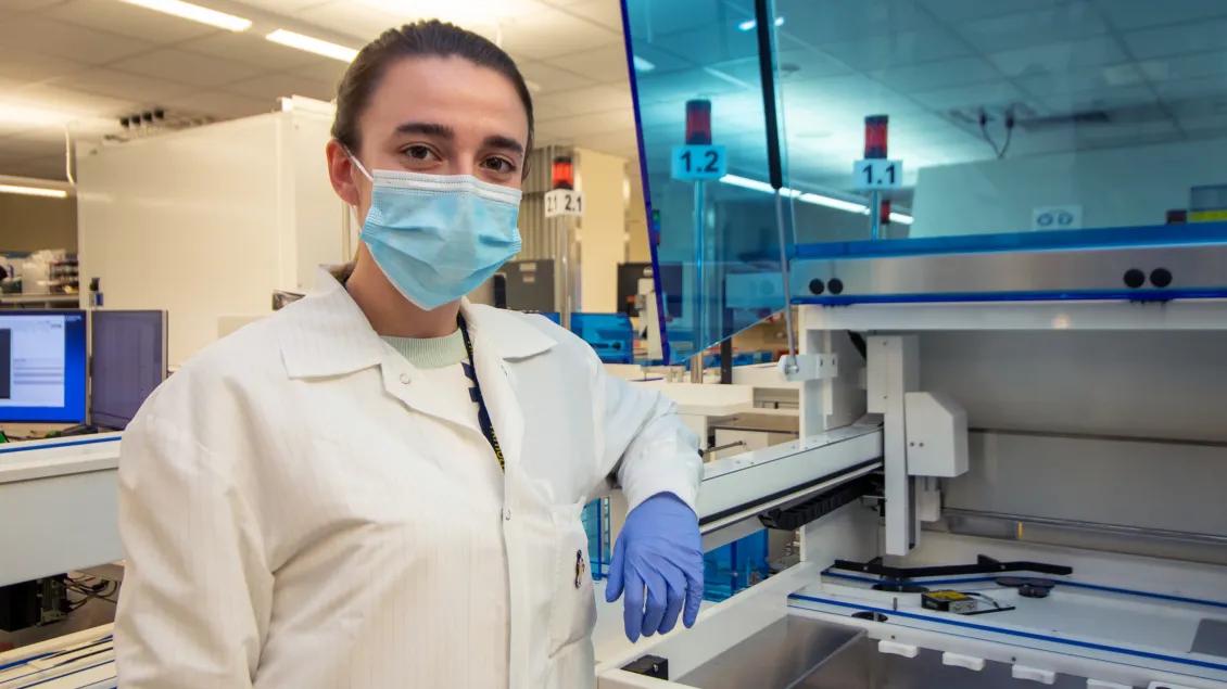 woman posing for photo in research lab wearing PPE