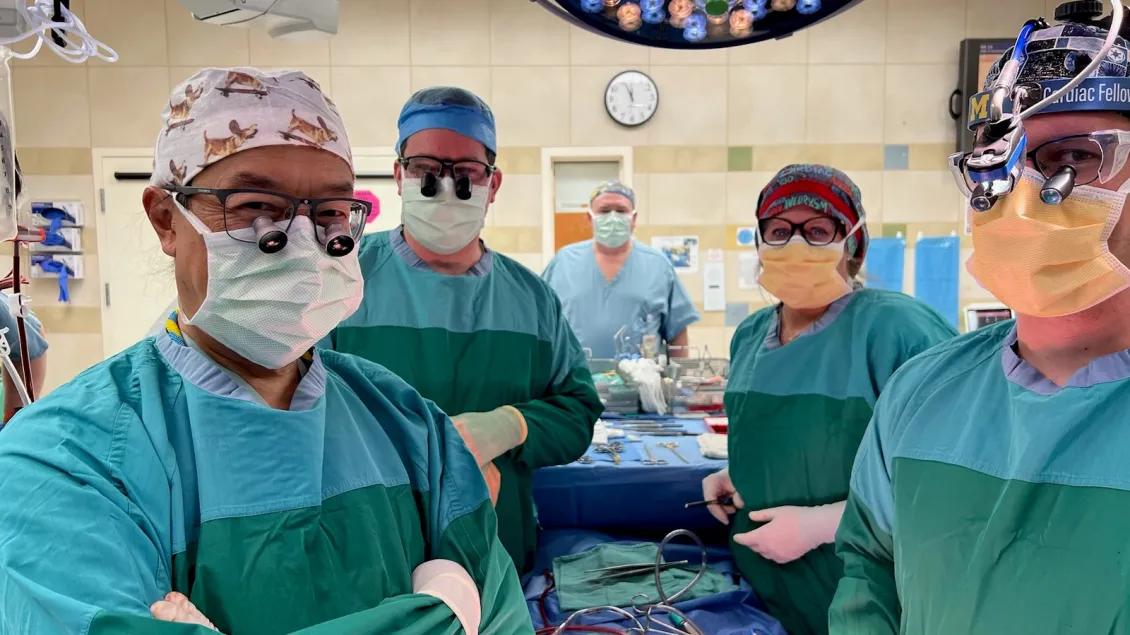 Fellows stand in an operating room and pose for the camera