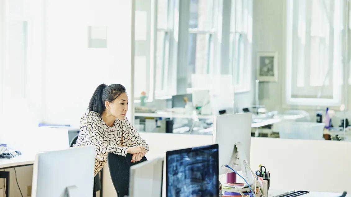 woman looking at computer in large office space