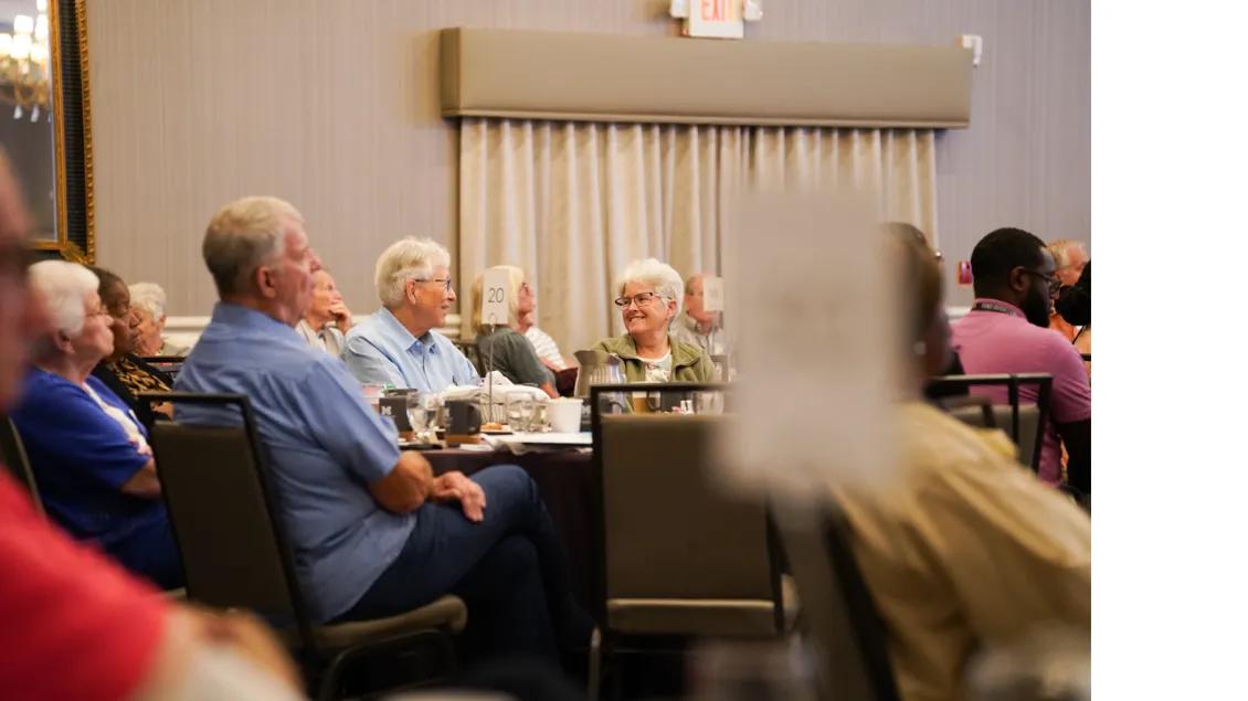 a group of older adults conversing around a table 