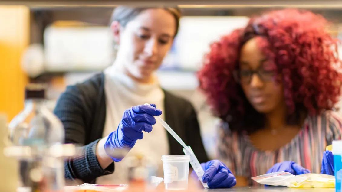 Two lab members using equipment in the lab