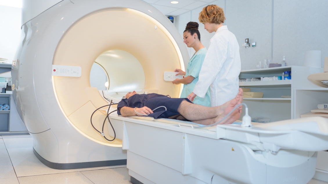 Patient in MRI with doctors besides him