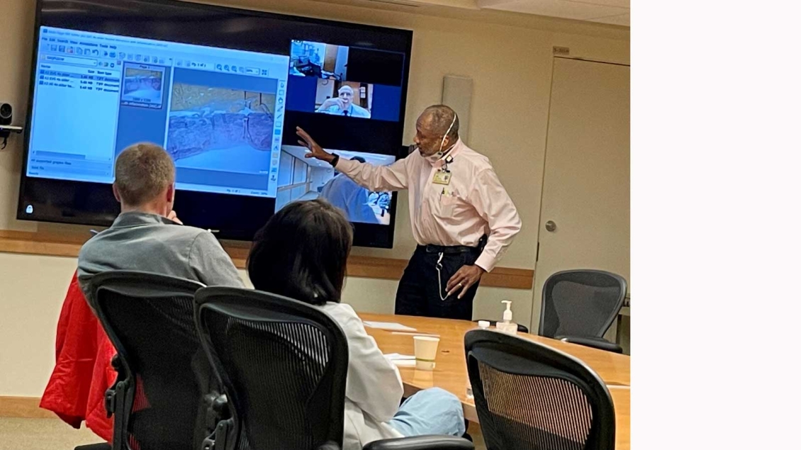Team discusses case on big screen in conference room