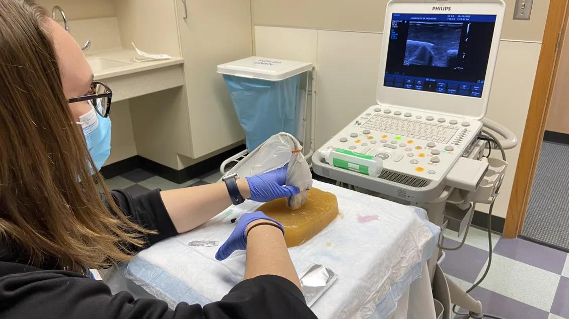 Ultrasound technician using medical device on equipment