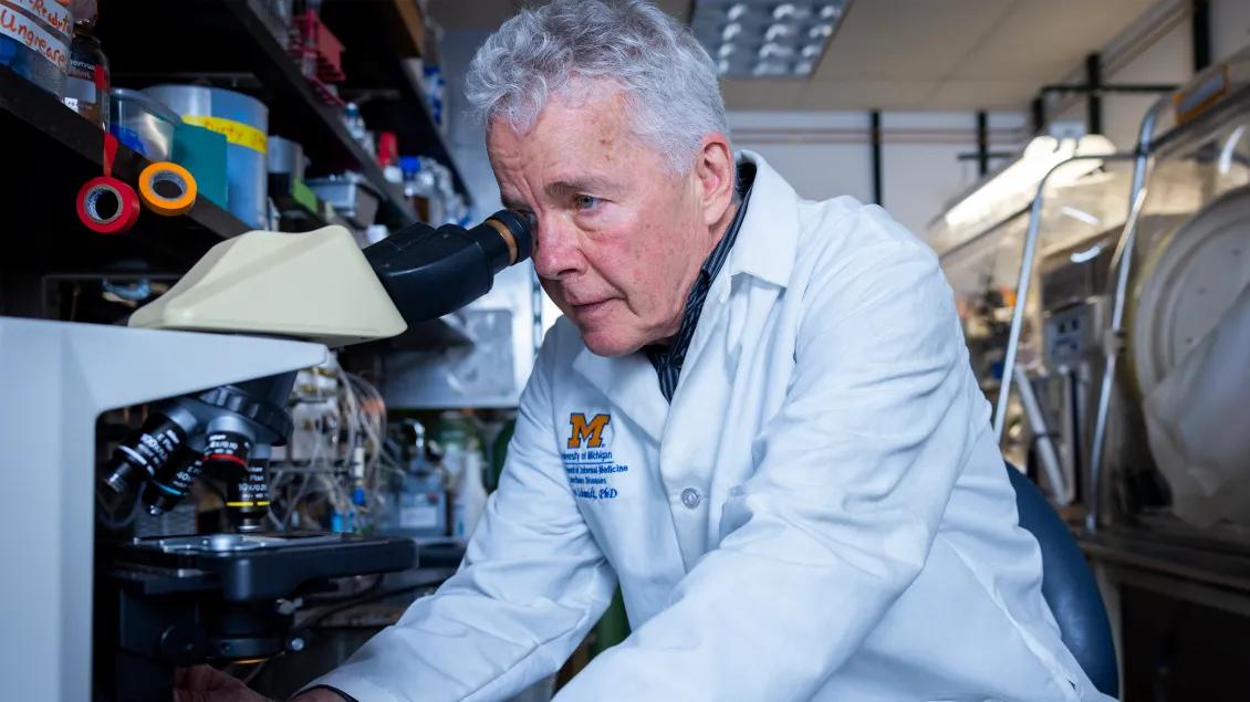 doctor looking through microscope in lab