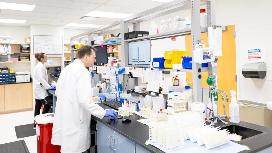 Photo of a woman and a man working inside the Michigan Clinical Research Unit processing lab