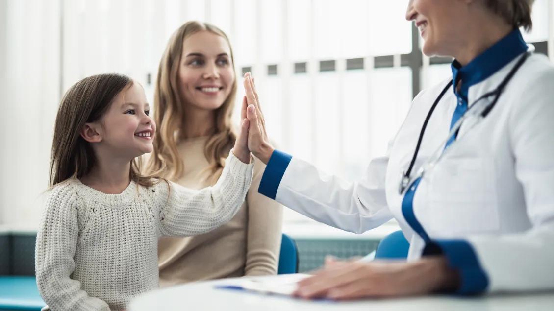 Child giving hi five to a Dr.