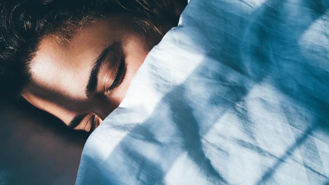 woman sleeping underneath blanket