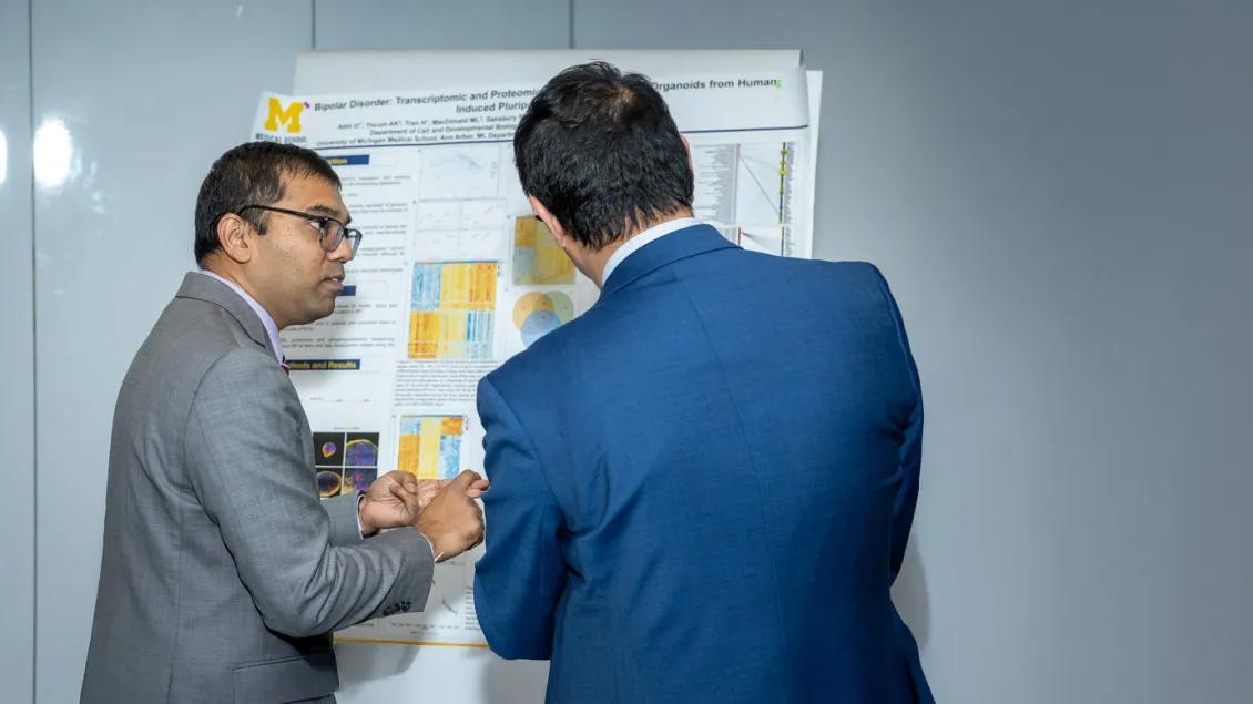 two men looking at poster presentation