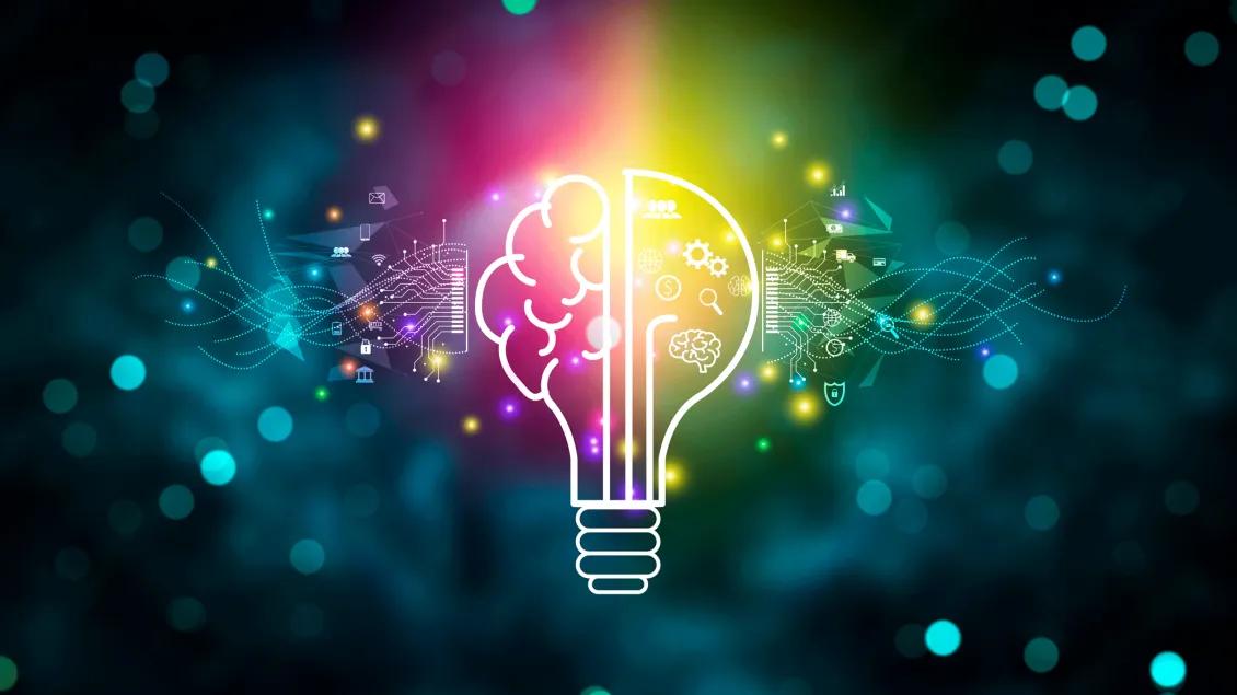 Colorful digital illustration of a glowing light bulb with a brain design inside it. The left half shows a stylized brain with circuit patterns, while the right half features icons such as gears, magnifying glass and graph. The background is dark with glowing bokeh and light trails, adding a dynamic, futuristic feel.