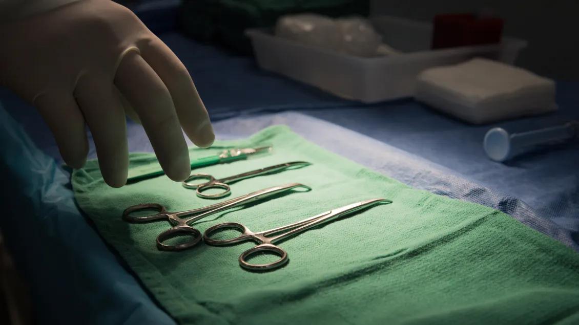View of hand reaching for medical tools
