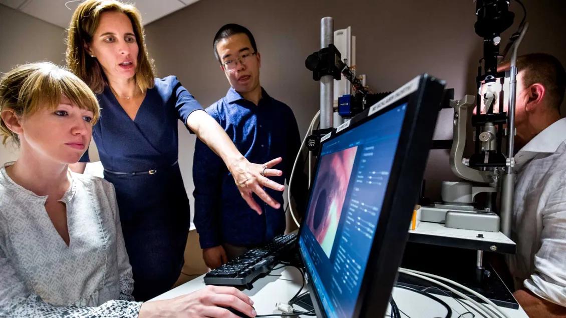 Mia Woodward shows research team eye research on computer screen